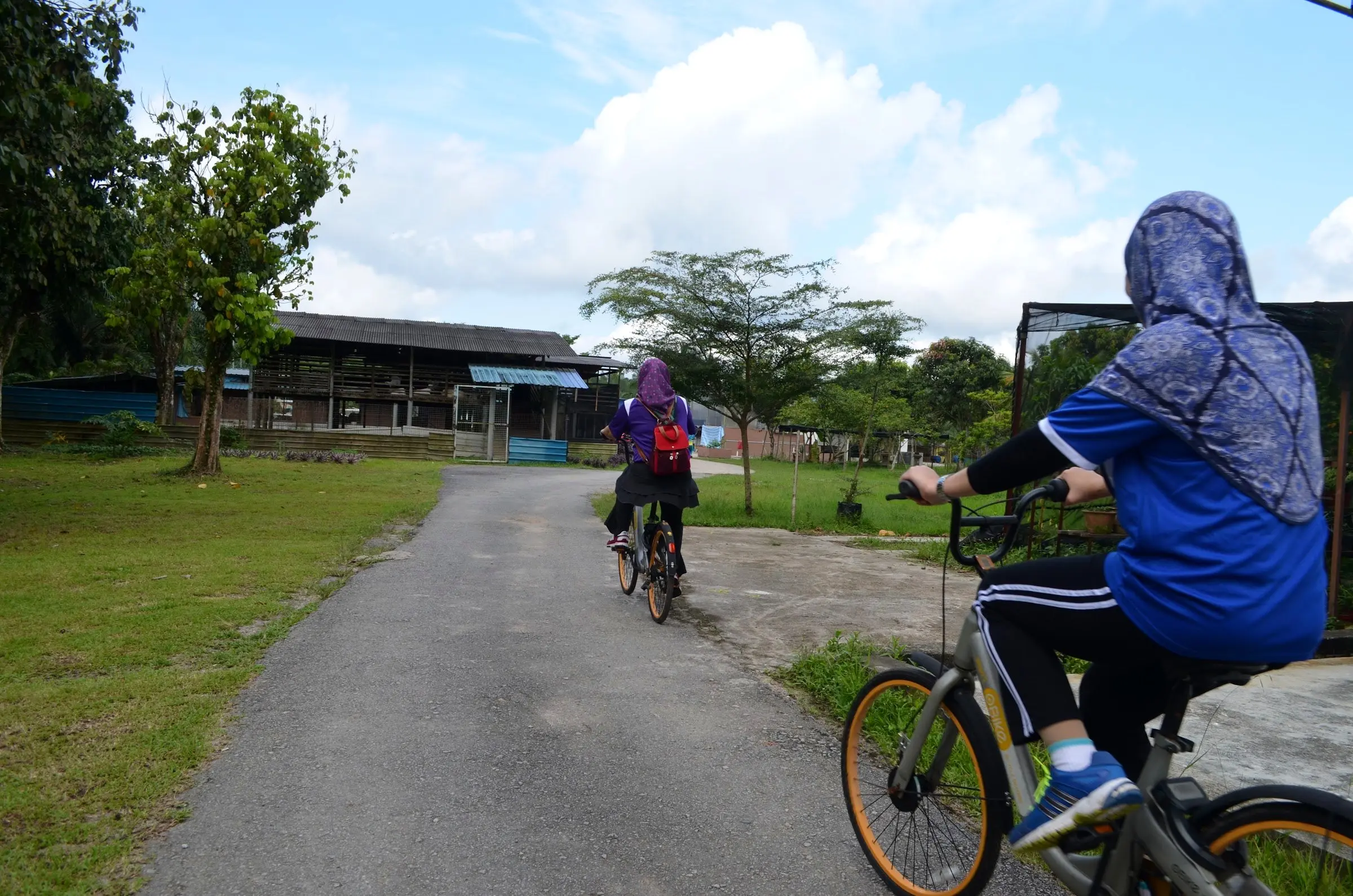 Guests cycle along a quiet paved path through the resort grounds