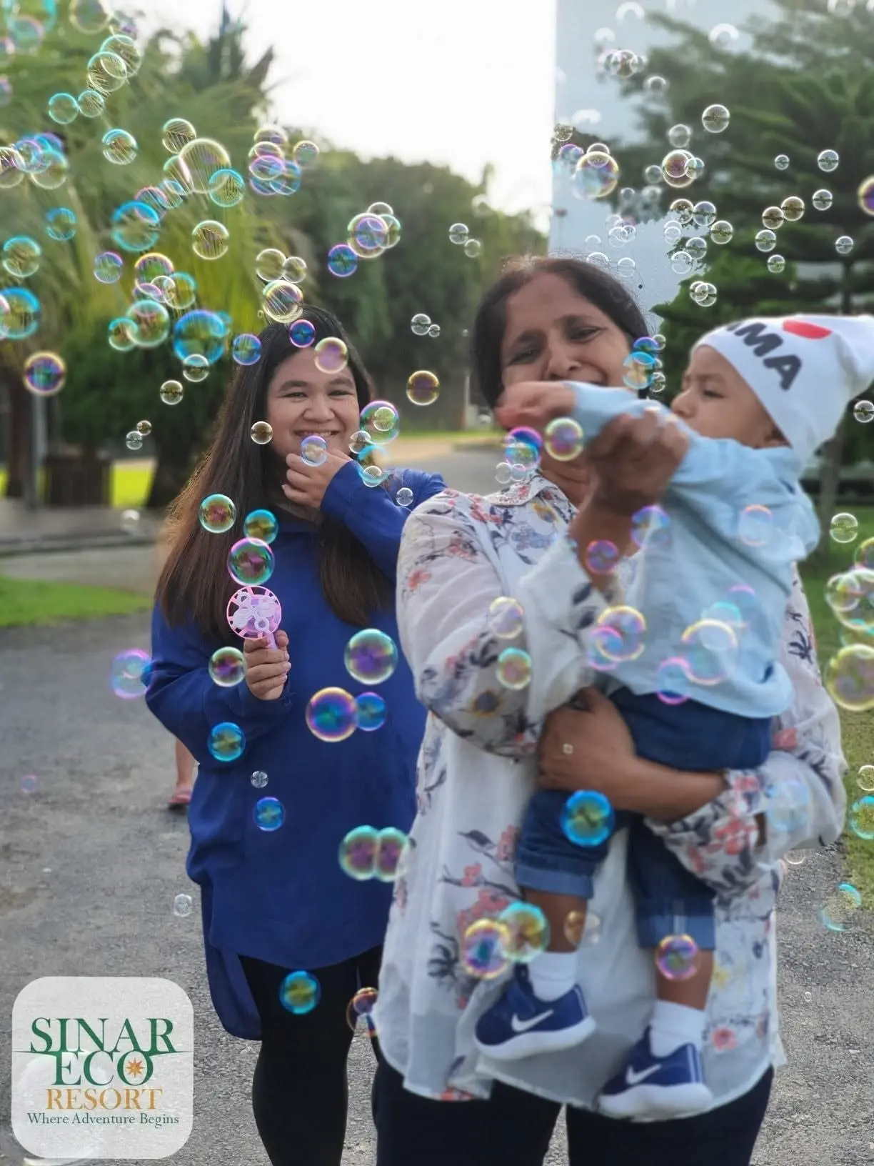 Three generations laugh among floating soap bubbles on the resort lawn