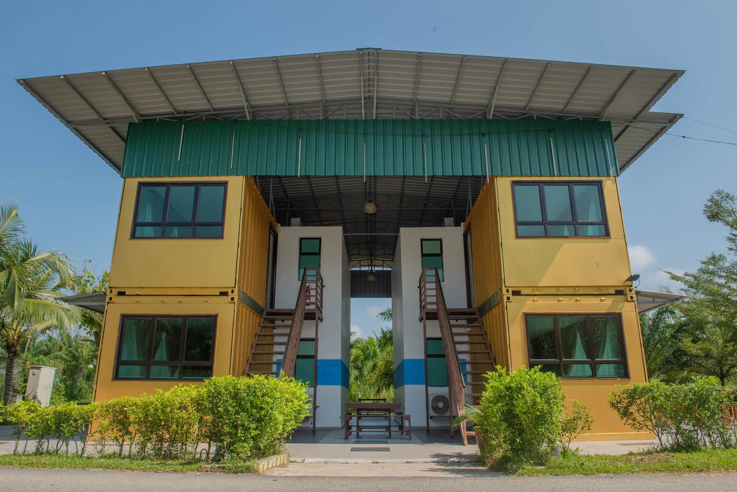 Front view of the two-storey yellow Container Room block with twin staircases