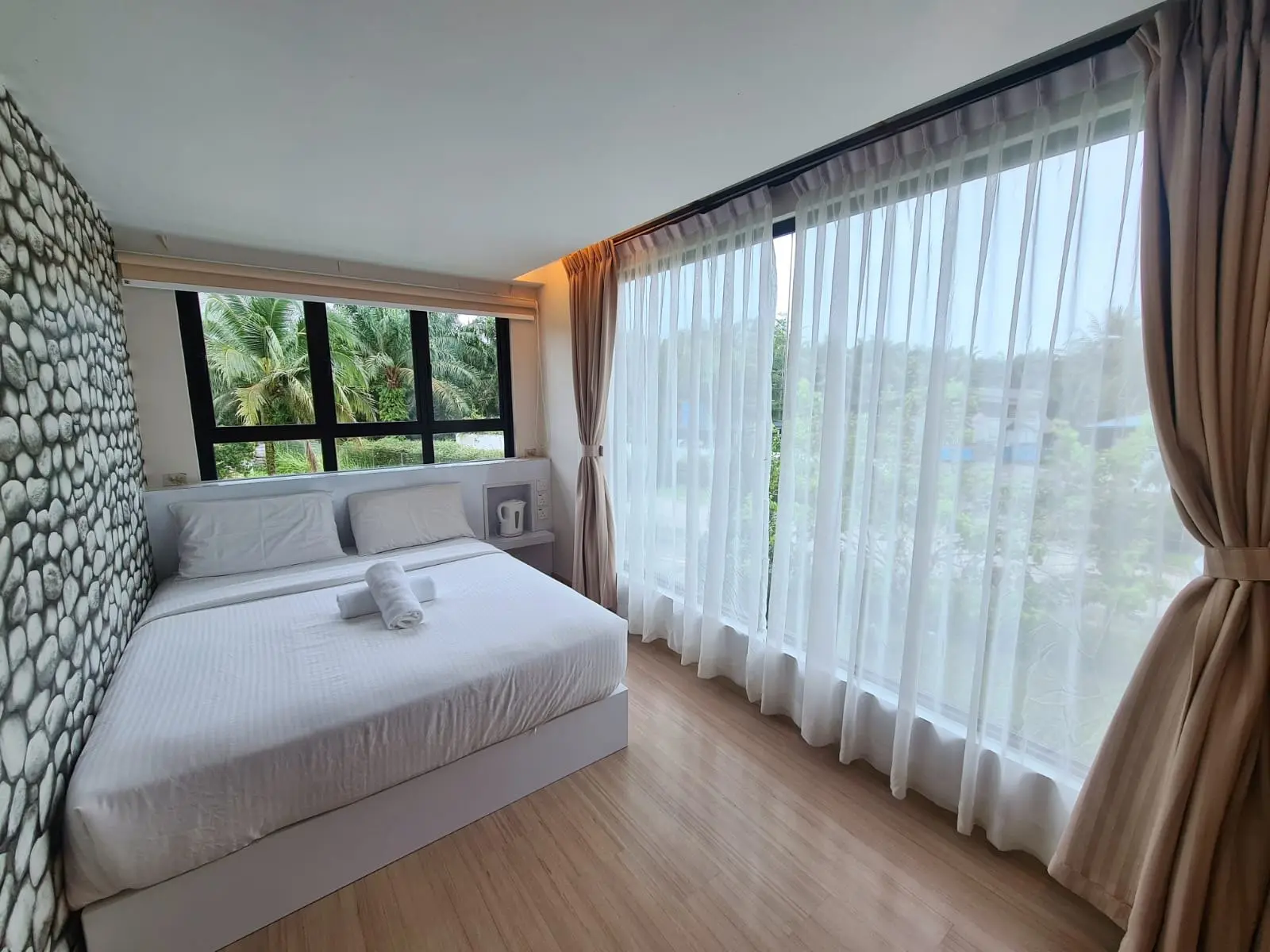 A bright Container Room with a queen bed and floor-to-ceiling windows