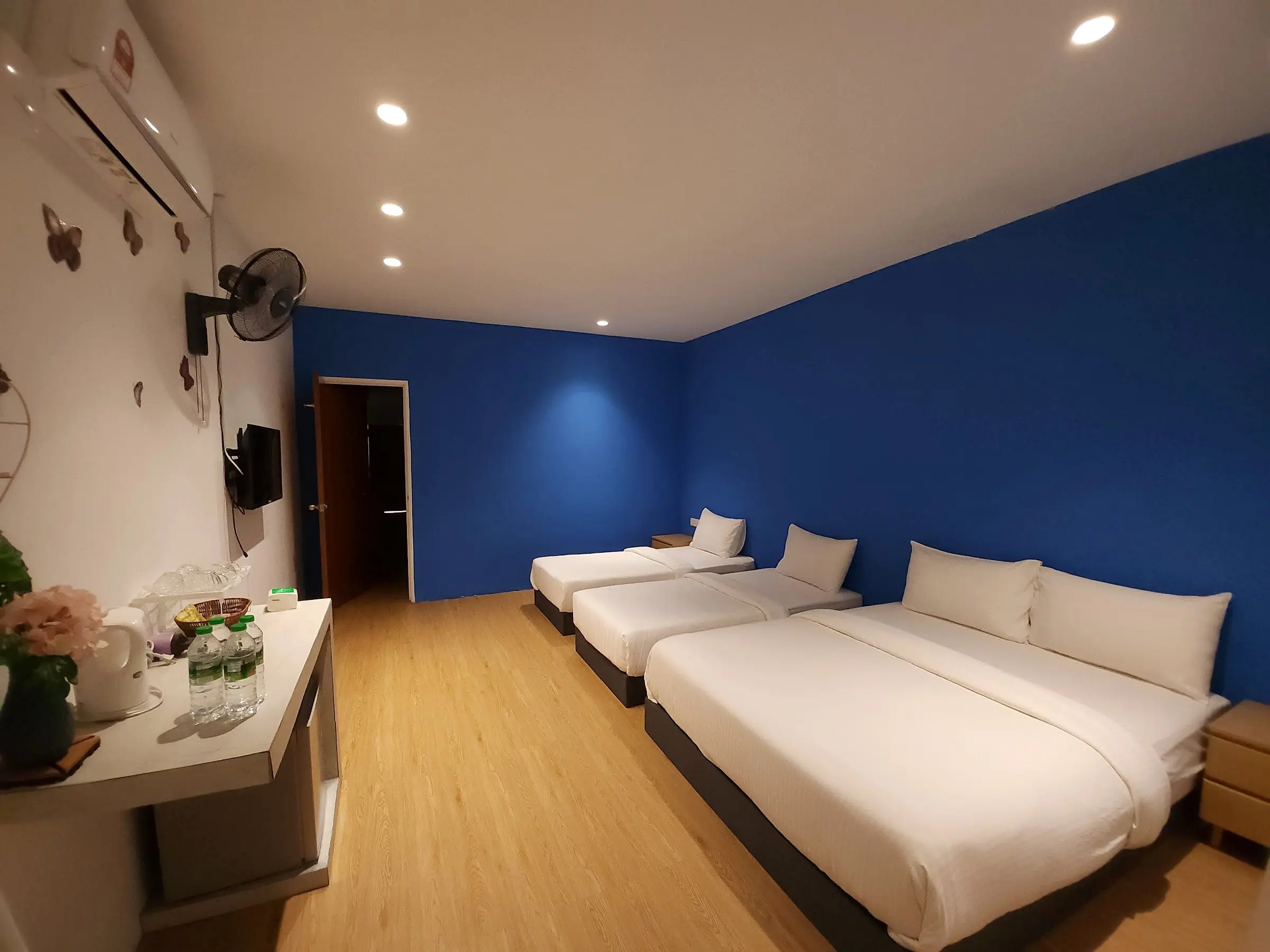 Family Room with a queen and two single beds, cobalt-blue wall, kettle and drinks station